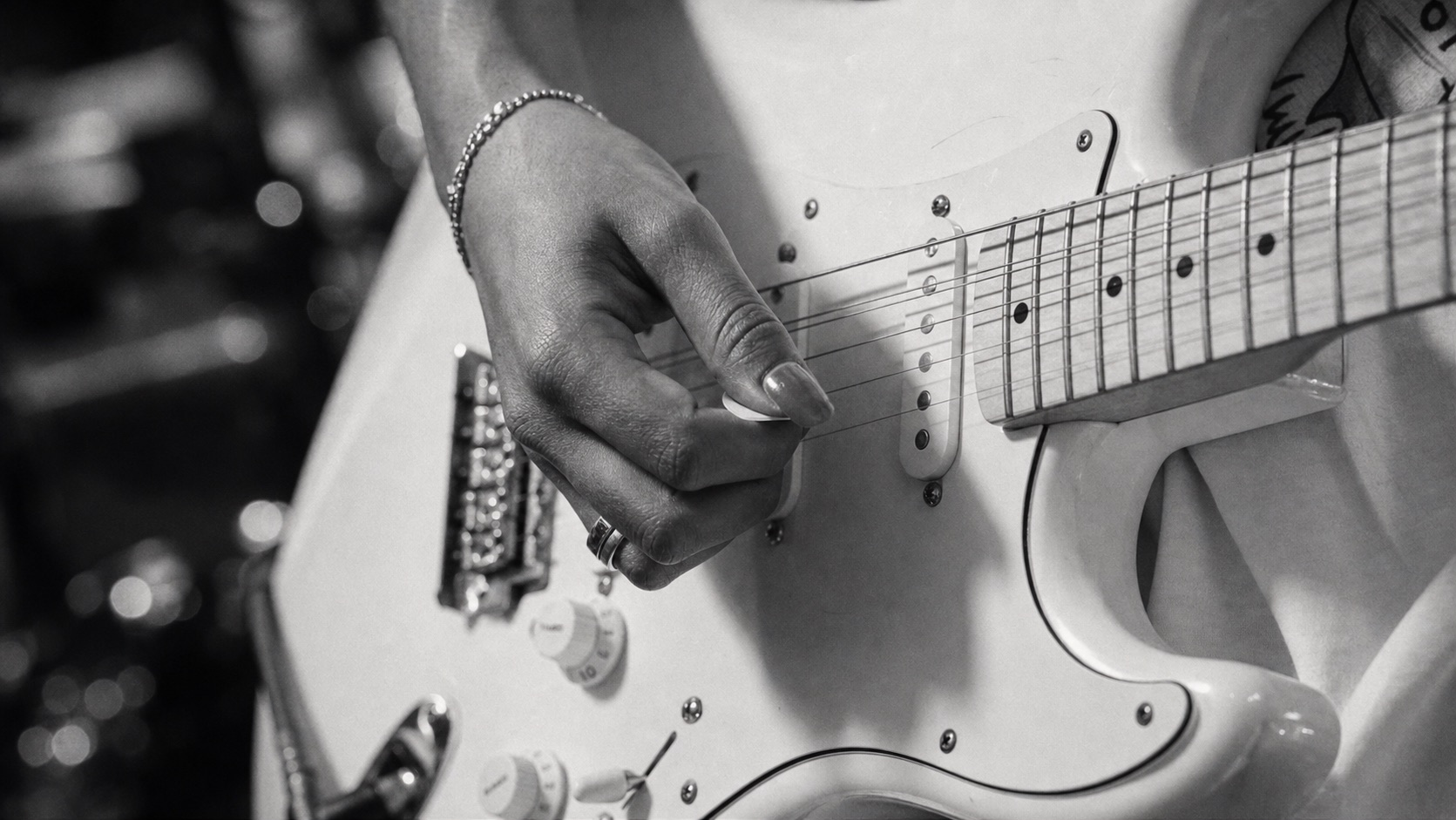 Close da mão de Purple Blaze tocando a guitarra creme